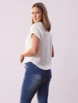 Remera blanca de tejido ribs con cuello a la base y escote en V. Tiene dos bolsillos aplicados en el frente y mangas cortas con dobladillo.