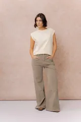 Pantalón de jean color arena con silueta wide leg, tiro medio-alto y costuras verticales delanteras que estilizan la figura. Cuenta con bolsillos funcionales y cierre frontal con doble botón.