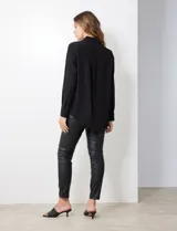 Camisa de satén color violeta, con cuello clásico, cierre frontal con botones, manga larga con puños anchos abotonados y bolsillo aplicado en el pecho.