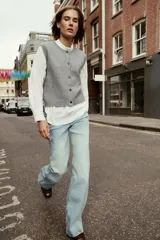 Chaleco de punto suave con cuello redondo, diseño sin mangas y cierre frontal con botones. Presenta terminaciones en rib en el cuello, sisas y ruedo.