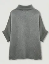 Capa tejida color fucsia, con cuello alto abotonado y mangas cortas estilo japonesa. Tejido de punto grueso.