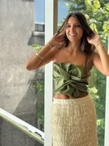 Top strapless de satén color bronce, con diseño de nudo frontal y drapeado estructurado.