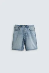 Bermuda de denim de algodón, color celeste claro con efecto lavado. Diseño de tiro medio, corte recto y largo hasta la rodilla. Presenta cinco bolsillos y cierre frontal con cremallera y botón.