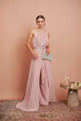 Mono de fiesta color rosa pálido, con cuello halter, cuerpo drapeado con lentejuelas y pantalón palazzo. Incluye cinturón con lentejuelas.