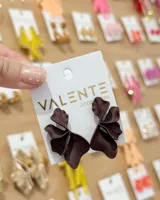 Aros colgantes en forma de flor con pétalos texturizados y acabado mate, color marrón oscuro.