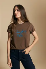 Remera de manga corta color marrón, con la frase "la dolce vita" bordada en azul en el frente y mangas con dobladillo.