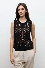 Top sin mangas confeccionado en tejido de crochet con patrón geométrico y floral, en color beige claro.