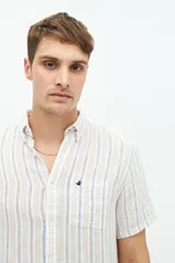 Camisa de manga corta confeccionada en lino y algodón, con fit regular y logo bordado. Color beige con rayas verticales blancas.