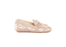 Mocasín de cuero gamuzado color avena, con bordados florales en blanco y apliques metálicos dorados. Presenta un lazo decorativo en la capellada y suela de goma flexible.