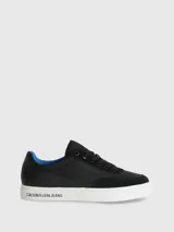 Zapatillas urbanas Calvin Klein con diseño de corte bajo. Presentan una combinación de materiales en la capellada, incluyendo paneles de nailon, cuero y ante en color negro. Destacan por su suela de goma blanca con el logo de la marca estampado en el lateral, forro interior en color azul vibrante y cierre mediante cordones.