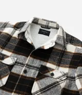 Campera de franela a cuadros con forro de sherpa, cuello tipo polo, cierre frontal con botones y bolsillos delanteros con solapa.