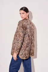 Campera color camel con diseño acolchado, cierre con botones a presión, cuello de piel sintética desmontable, bolsillos delanteros y puños ajustables con lazo.