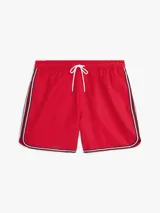 Short de baño rojo con cintura elástica ajustable con cordón blanco. Tiene dos bolsillos laterales y un bolsillo trasero de parche. El bajo presenta una franja con los colores azul marino, blanco y rojo.