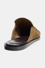 Mocasín destalonado de serraje color marrón, con diseño de copete subido, detalle de antifaz con pespunte y punta redonda.