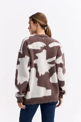 Sweater de punto con diseño abstracto bicolor en tonos marrón y blanco, de silueta amplia y relajada, con cuello redondo y mangas largas.