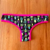 Bombacha vedetina negra con estampado de ananás multicolor y ribete fucsia.