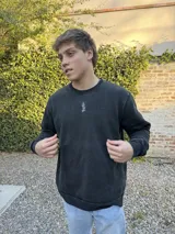 Buzo negro de algodón con cuello redondo y logo bordado en el pecho.