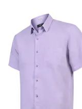 Camisa de lino color lila, de manga corta, con cuello camisero, cierre frontal de botones y un bolsillo aplicado en el pecho.