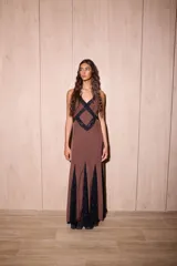 Vestido largo marrón con estampado de lunares, tirantes finos, escote en V con apliques de encaje negro formando un diseño geométrico en el pecho, y paneles de encaje negro en el ruedo.
