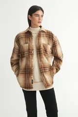 Sobrecamisa marrón a cuadros confeccionada en tela de algodón. Tiene cuello solapa clásico, bolsillos cuadrados en el pecho, botones personalizados y calce holgado.