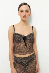 Top de encaje con estampado animal print, con breteles finos y lazo de terciopelo en el centro del busto.