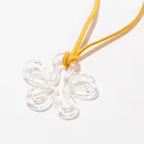 Collar con dije de flor transparente y cordón fino color mostaza.