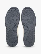 Zapatillas de baloncesto Tommy Hilfiger de corte bajo, color blanco con detalles en gris, azul y suela bitonal. Presentan exterior de piel con paneles de ante y mezcla de texturas, cordones blancos y detalles distintivos de la marca.