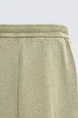 Pantalón relaxed fit tejido en hilatura de algodón con estructura, color verde militar. Presenta cintura elástica ajustable con cordón en contraste, bolsillos de vivo frontales y detalle de bolsillo trasero.
