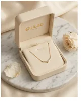 Collar de acero con baño de oro, con dije en forma de V decorado con circonias engastadas.