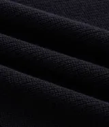 Suéter masculino de punto texturizado en color beige, con cuello polo, cierre frontal de tres botones, manga larga y terminaciones acanaladas en puños y ruedo.