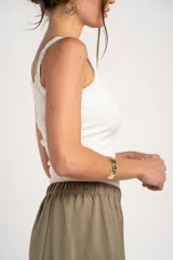 Musculosa off white de algodón peinado elastizado, con calce al cuerpo, escote redondo y detalles de encaje en el escote y los tirantes.