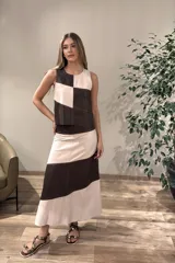 Falda larga de cuero, con diseño de bloques de color en marrón oscuro y crudo, con corte al bies.