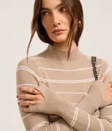 Suéter de punto negro con rayas horizontales blancas, cuello alto y mangas largas.