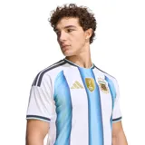 Camiseta de fútbol Adidas de la Selección Argentina, modelo Home 2026. Diseño a rayas verticales blancas y celestes con detalles en negro en cuello y mangas. Incluye logo de Adidas, escudo de AFA y parche de campeón del mundo.