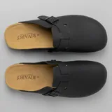 Zuecos negros con plantilla de corcho y hebilla ajustable.