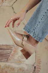 Zapato de charol negro con hebilla metálica ajustable y taco cuadrado.