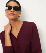 Cardigan de punto fino color gris, con escote en V, cierre frontal con botones y mangas largas. Confeccionado en una mezcla de viscosa y poliamida.