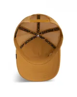 Gorra tipo trucker de color beige con frente de gamuza sintética y parte trasera de malla. Presenta un parche bordado en el frente con la imagen de una cabra y la inscripción G.O.A.T. sobre fondo dorado metálico.