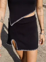 Minifalda negra tejida en algodón, con pespuntes en color crudo.