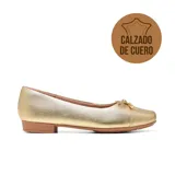 Zapato chatita de cuero color dorado con terminación metalizada, punta redonda y detalle de lazo pequeño con punteras metálicas en la parte frontal. Cuenta con un sutil tacón cuadrado y suela marrón.