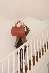 Bolso de mano tipo shopper marca Amadea, confeccionado en cuero con acabado desgastado. Presenta detalles de costuras decorativas verticales, correas con hebillas metálicas doradas y logo grabado al frente.