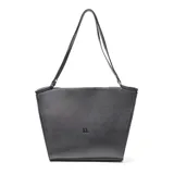 Cartera tipo tote de cuero negro con textura granulada, diseño trapezoidal y logo de la marca grabado en el centro. Cuenta con correas largas para llevar al hombro.