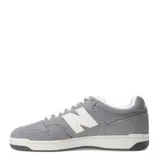 Championes New Balance modelo 480 Lifestyle, color gris con detalles en blanco. Presentan una construcción de gamuza y malla, con el logo 'N' en blanco en el lateral y suela de goma en dos tonos (blanco y gris oscuro).