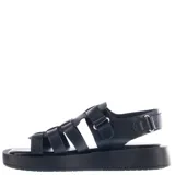 Sandalias de estilo franciscano con diseño tejido, confeccionadas en material sintético color negro. Presentan una suela tipo plataforma plana y cierre con ajuste de velcro en el talón.