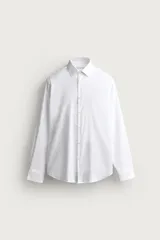 Camisa de vestir blanca de corte slim fit, confeccionada en tejido de algodón con textura estructurada. Cuenta con cuello italiano, mangas largas con puños abotonados y cierre frontal con botonadura.