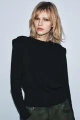 Jersey de punto color marrón oscuro, con cuello redondo, manga larga y hombreras con pliegues.