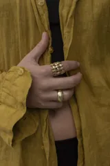 Anillo de diseño abierto con estructura de rejilla entrelazada, elaborado artesanalmente en metal con acabado plateado.