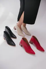 Botines de cuero color beige con diseño de tajo frontal, punta fina y taco cuadrado de madera.