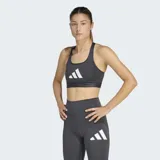 Top deportivo Adidas de bajo impacto, confeccionado en tejido técnico con tecnología AEROREADY de absorción de humedad. Presenta un diseño de espalda racer-back, cuello escotado y banda elástica inferior para mayor soporte, con el logo de la marca estampado en el frente.