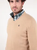 Sweater de cashmere color beige con cuello en V y logo bordado en el pecho.